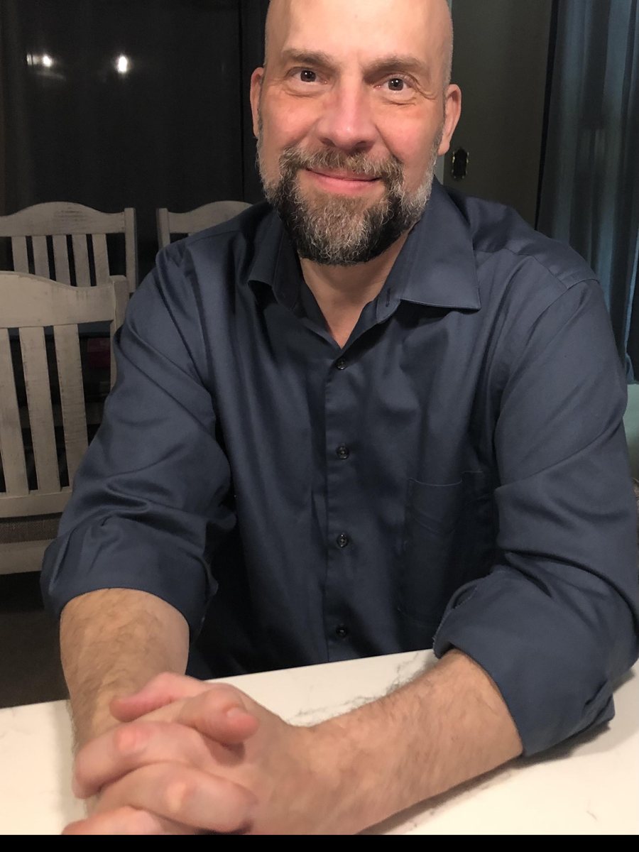 Terry Christopher seated at a table, smiling